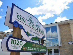 A sign for The Inn on College Drive, College Drive Lodge Inc., with a contact number and address.