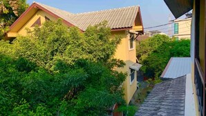 A residential building with a sloped roof, surrounded by dense greenery. - Thapae Boutique House (Chiang Mai)