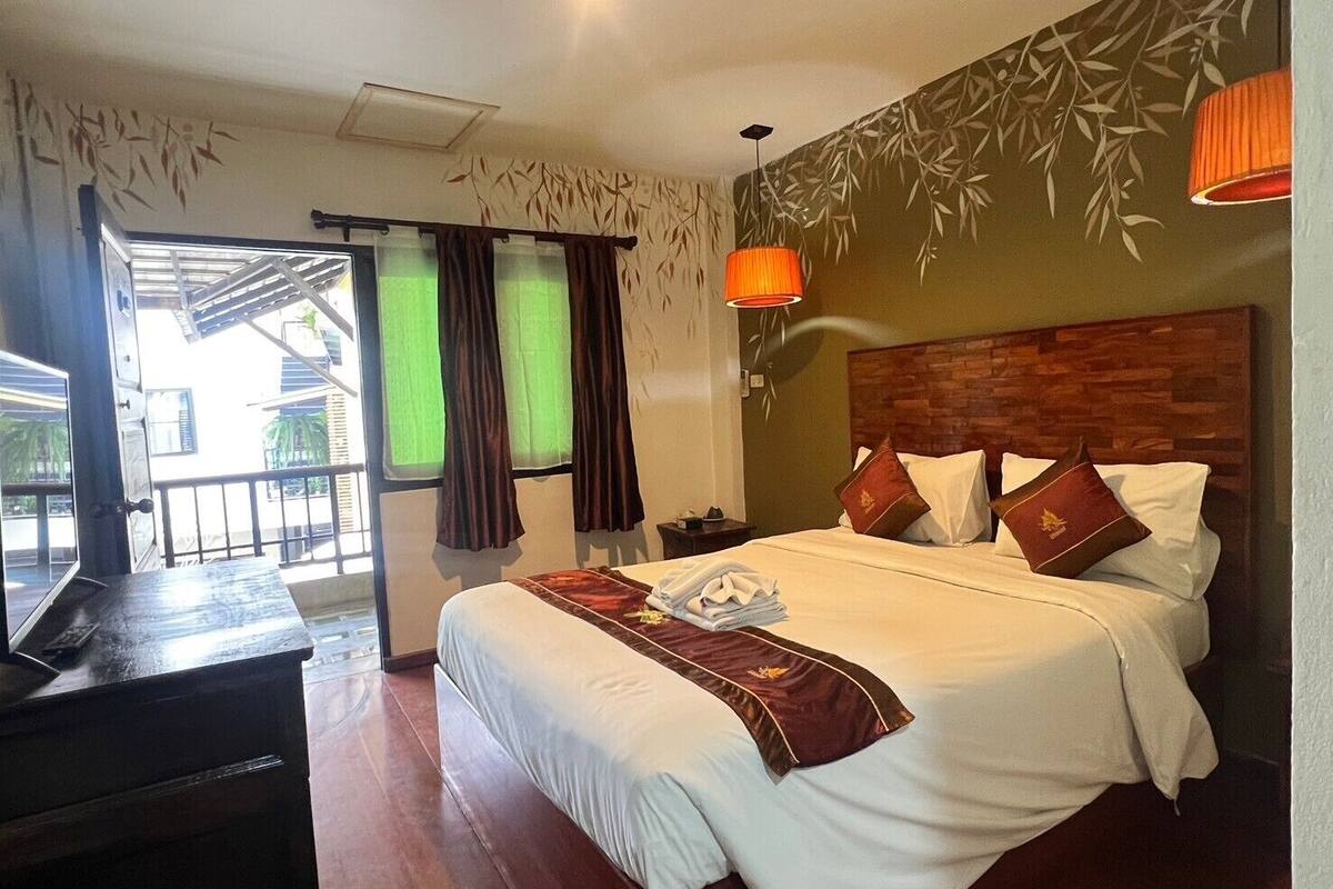 Une chambre d’hôtel avec un lit, un bureau et une vue sur l’extérieur.
