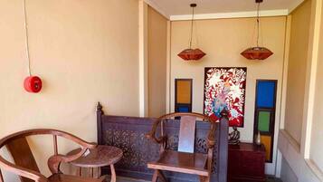 Una habitación con un banco de madera, una mesita y un adorno en la pared.