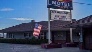 A motel with a signboard advertising new management and a 50-inch flat screen TV. - Bay Bridge Motel (North Bend)