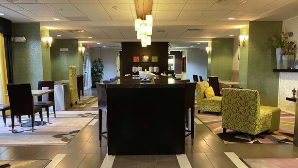 A hotel lobby with a reception desk, seating area, and a large potted plant. - Hampton Inn by Hilton Leesville Fort Polk (Leesville)