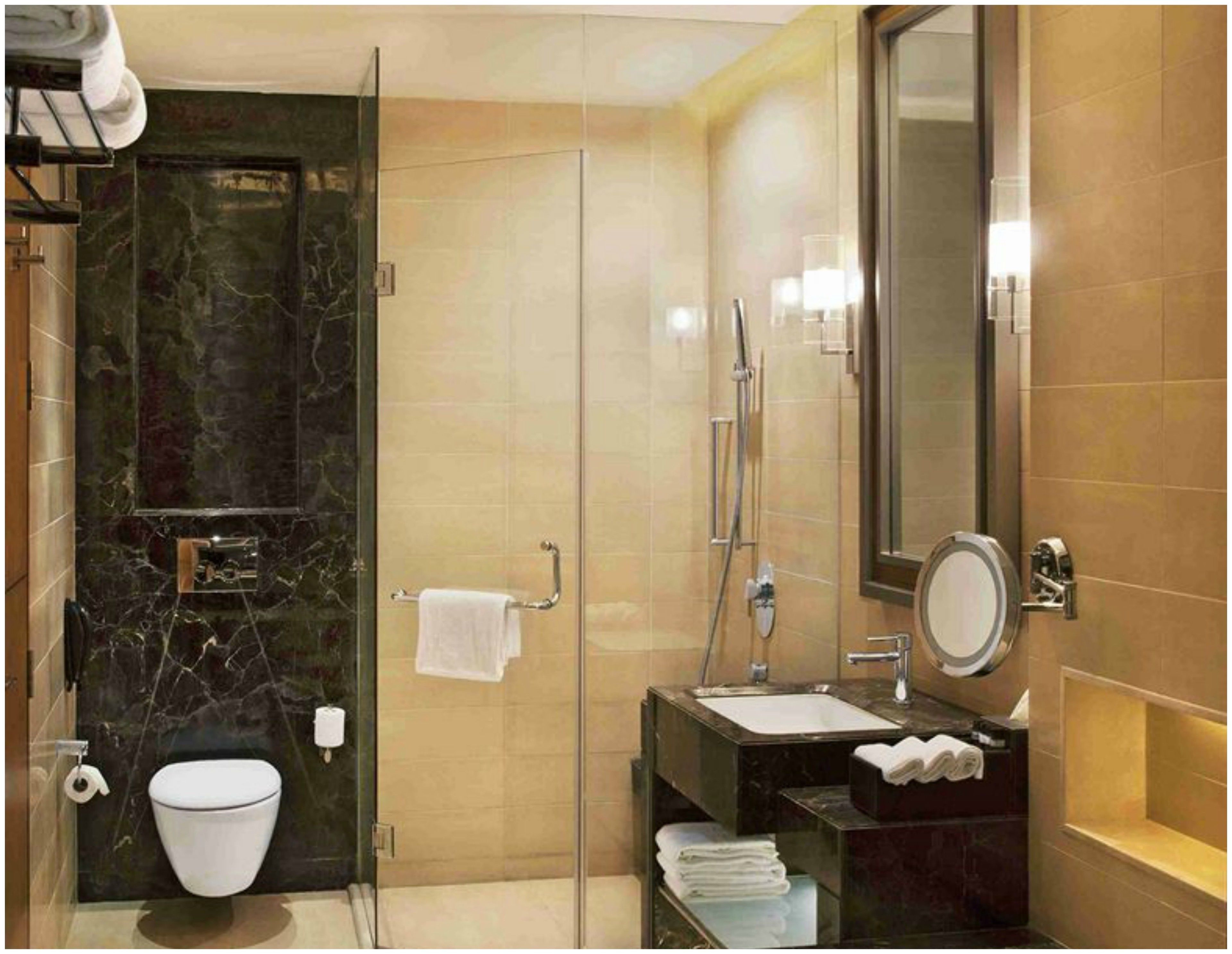 A modern bathroom with a glass-enclosed shower, a marble vanity, and a large mirror.
