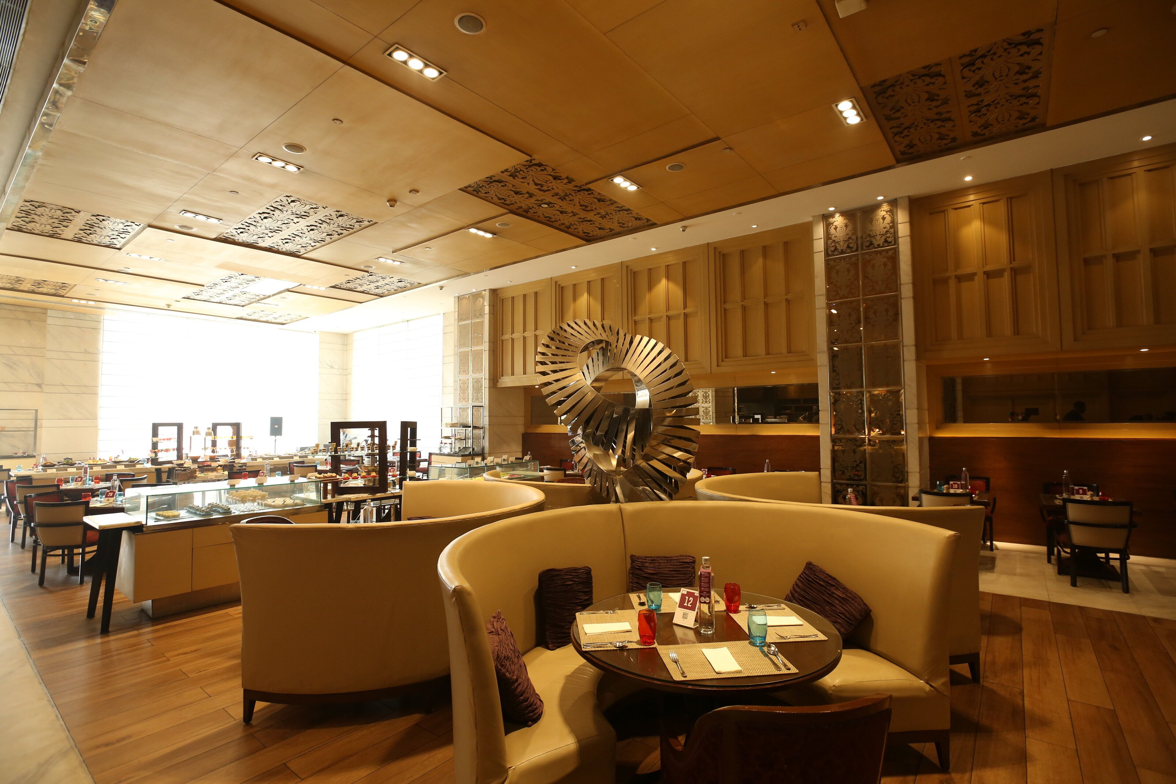 A modern hotel lobby with a central spiral staircase, comfortable seating areas, and a well-lit interior.