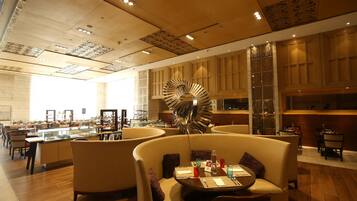 A modern hotel lobby with a central spiral staircase, comfortable seating areas, and a well-lit interior.