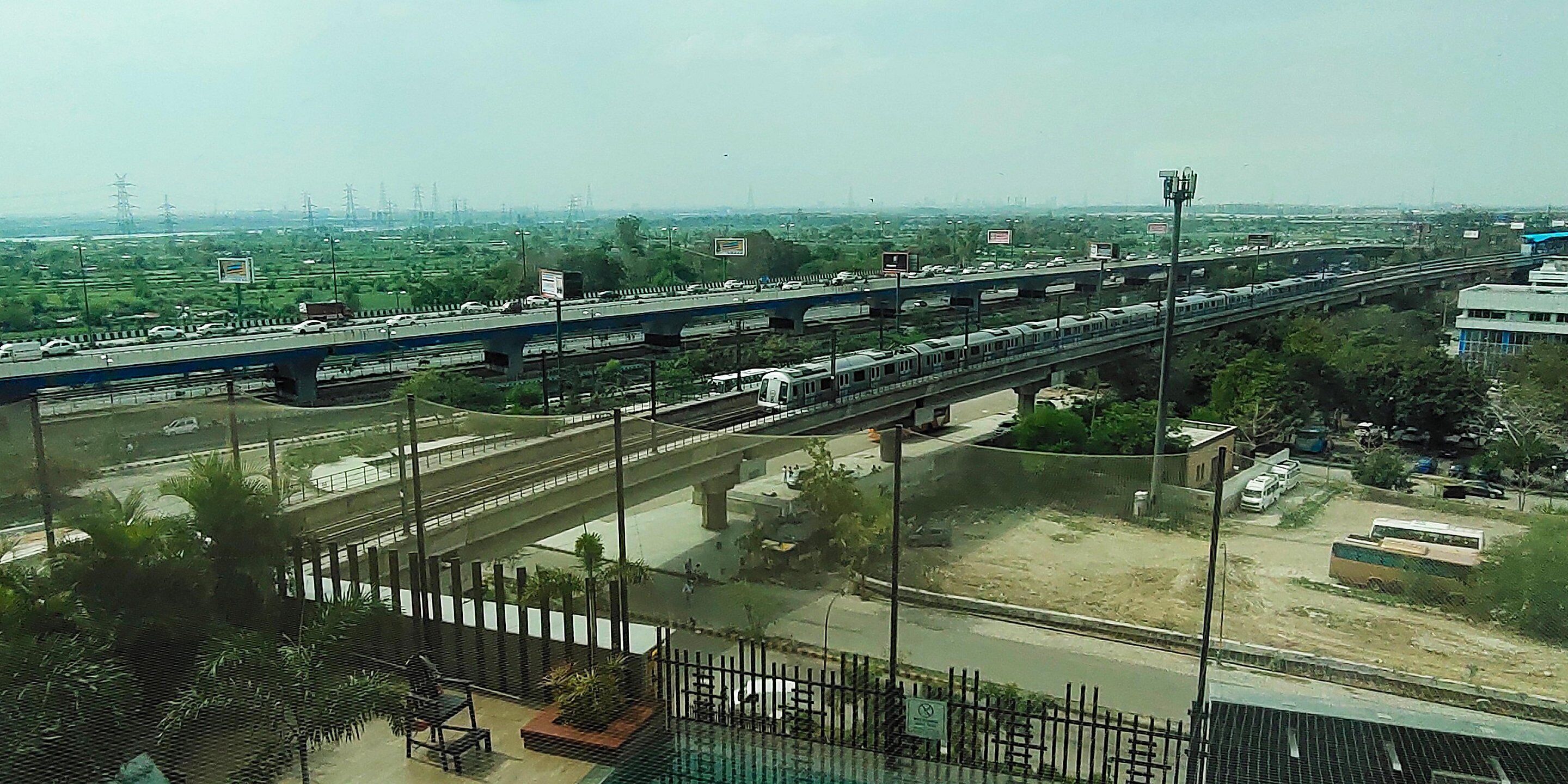 A multi-level highway with vehicles, including cars and a train, passing over it.
