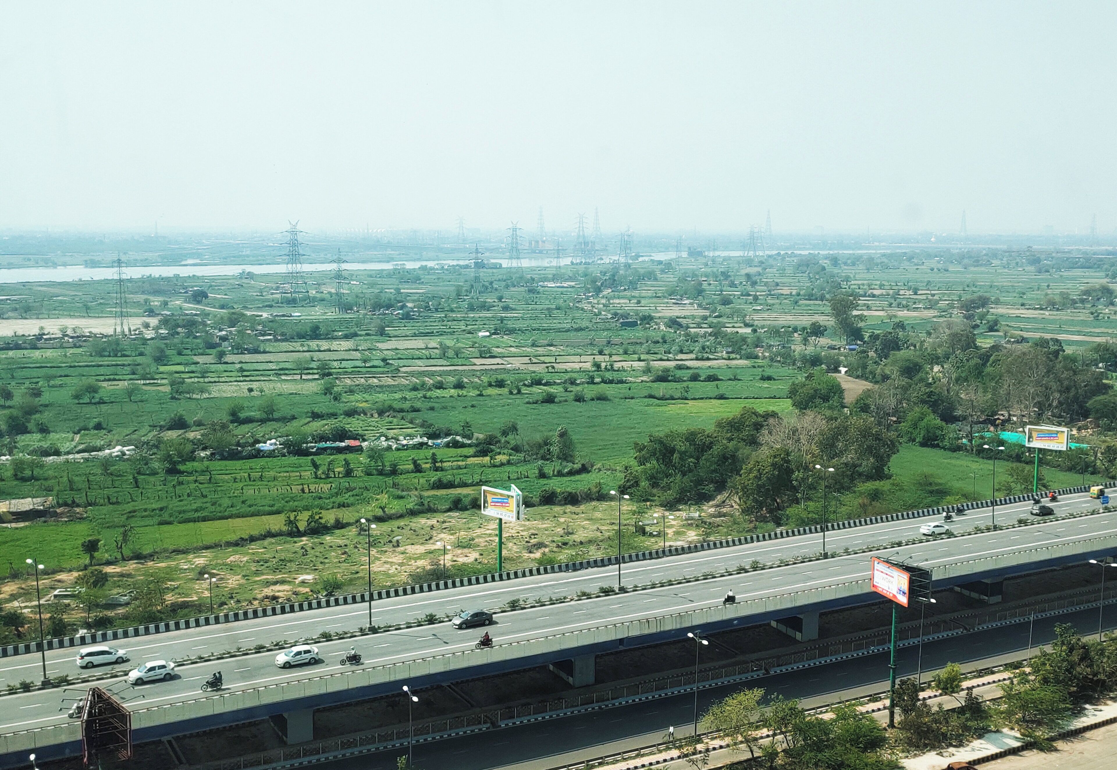 A highway with multiple lanes and vehicles, including cars and motorcycles.