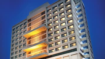 A high-rise building with multiple balconies and illuminated windows, suggesting a hotel or residential complex.
