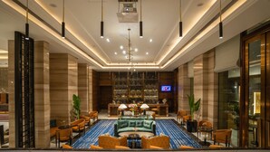 A spacious lobby with a central seating area, a bar, and a television screen. - Crowne Plaza New Delhi Mayur Vihar Noida by IHG (New Delhi)