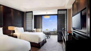 A hotel room with two beds, a desk with a TV, and a balcony with a view. - Crowne Plaza New Delhi Mayur Vihar Noida by IHG (New Delhi)