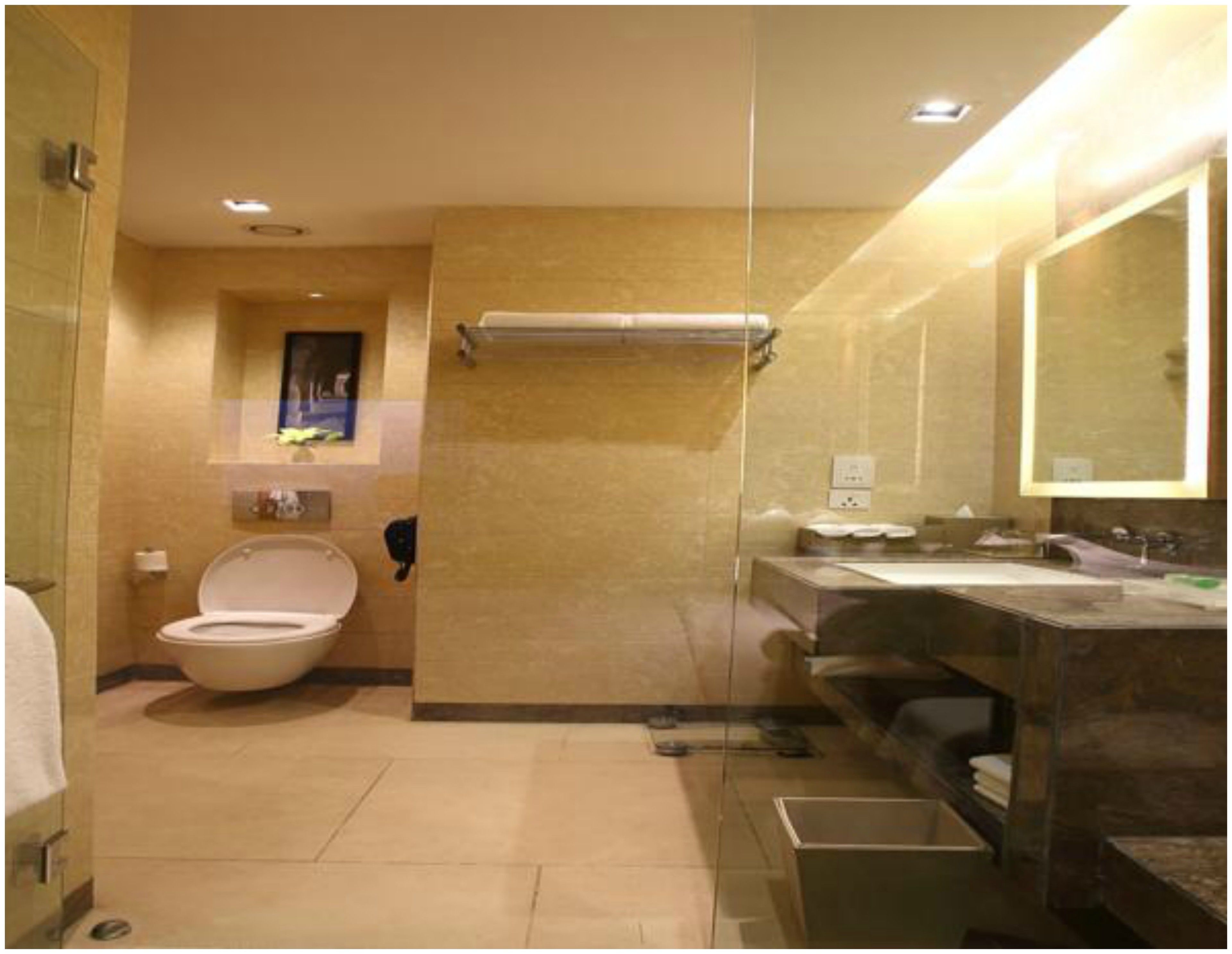 A modern bathroom with a toilet, sink, and mirror.