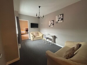 Habitación cuádruple familiar | Área de sala de estar | Televisión de pantalla plana y reproductor de DVD 