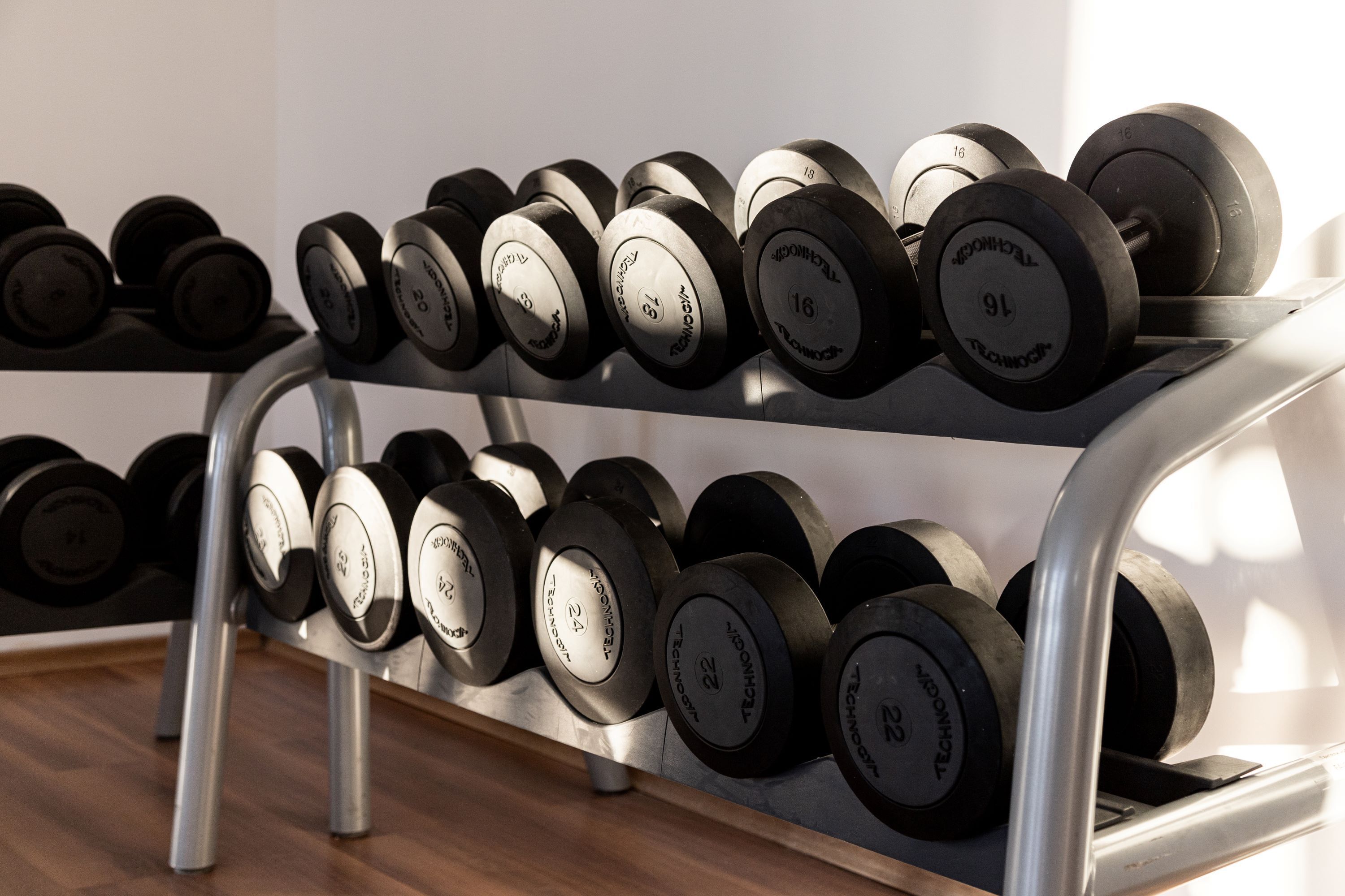 A rack of dumbbells with various weight markings.