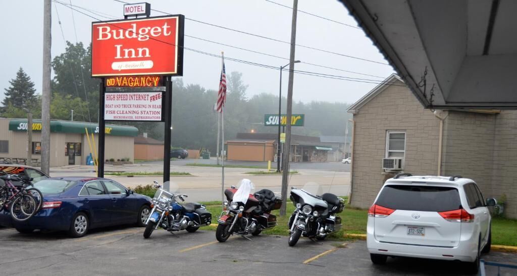 A motel named Budget Inn with a sign indicating no vacancy.