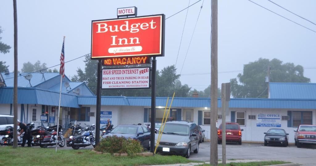 Budget Inn motel met een bord waarop staat 'volgeboekt' en voorzieningen zoals snelle internetverbinding, parkeerplaats voor boten en vrachtwagens, plus een visreinigingsstation.