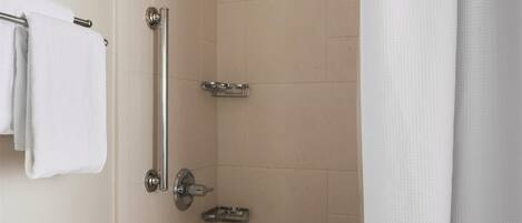 A bathroom with a bathtub, a shower, a grab bar, and a towel rack.