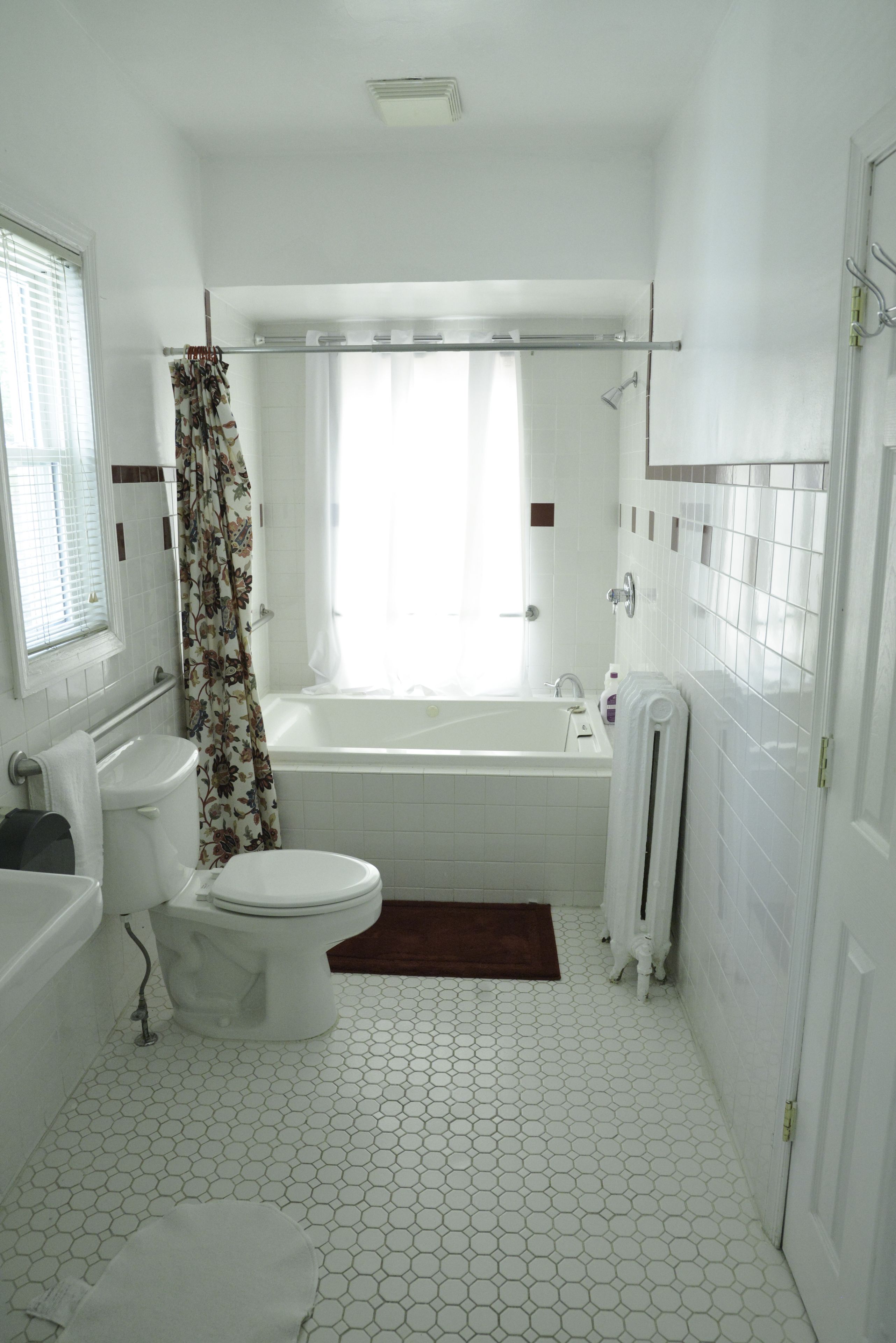 A bathroom with a toilet, bathtub, and shower curtain.