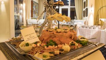 A buffet table with various dishes and a sign indicating the menu.