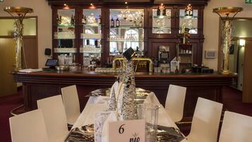 A bar area with a long counter, multiple shelves with bottles and glasses, and a seating area with a table numbered 6.