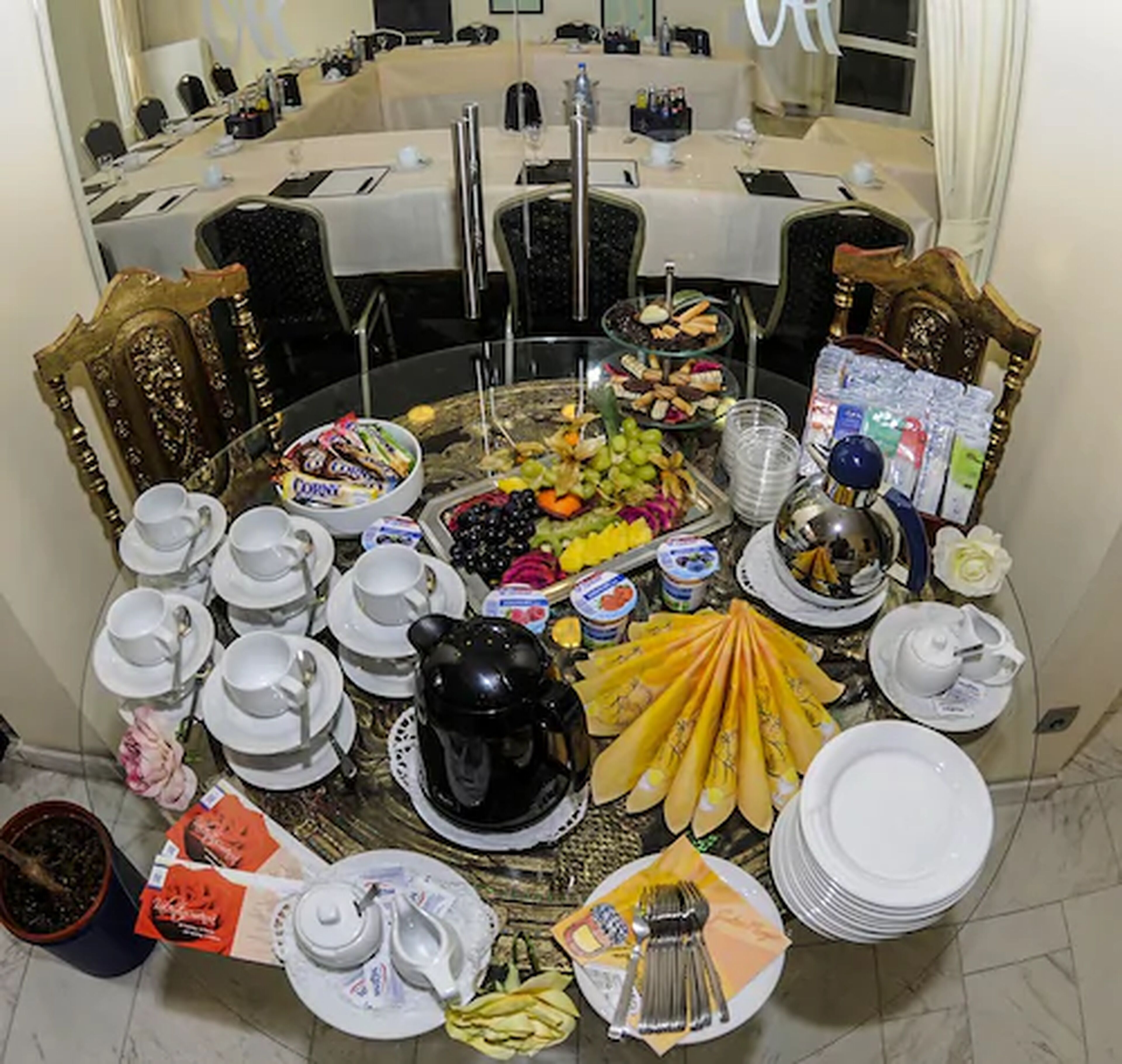 A buffet setup with various food items, tea sets, and utensils arranged on a table.