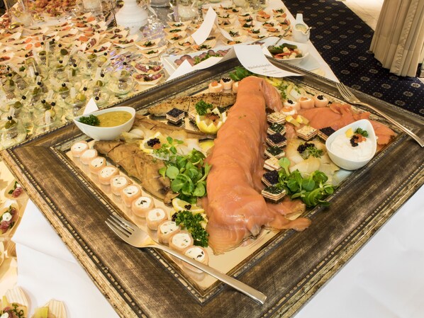 Una gran bandeja de comida que incluye un cerdo asado entero, diferentes quesos y adornos.