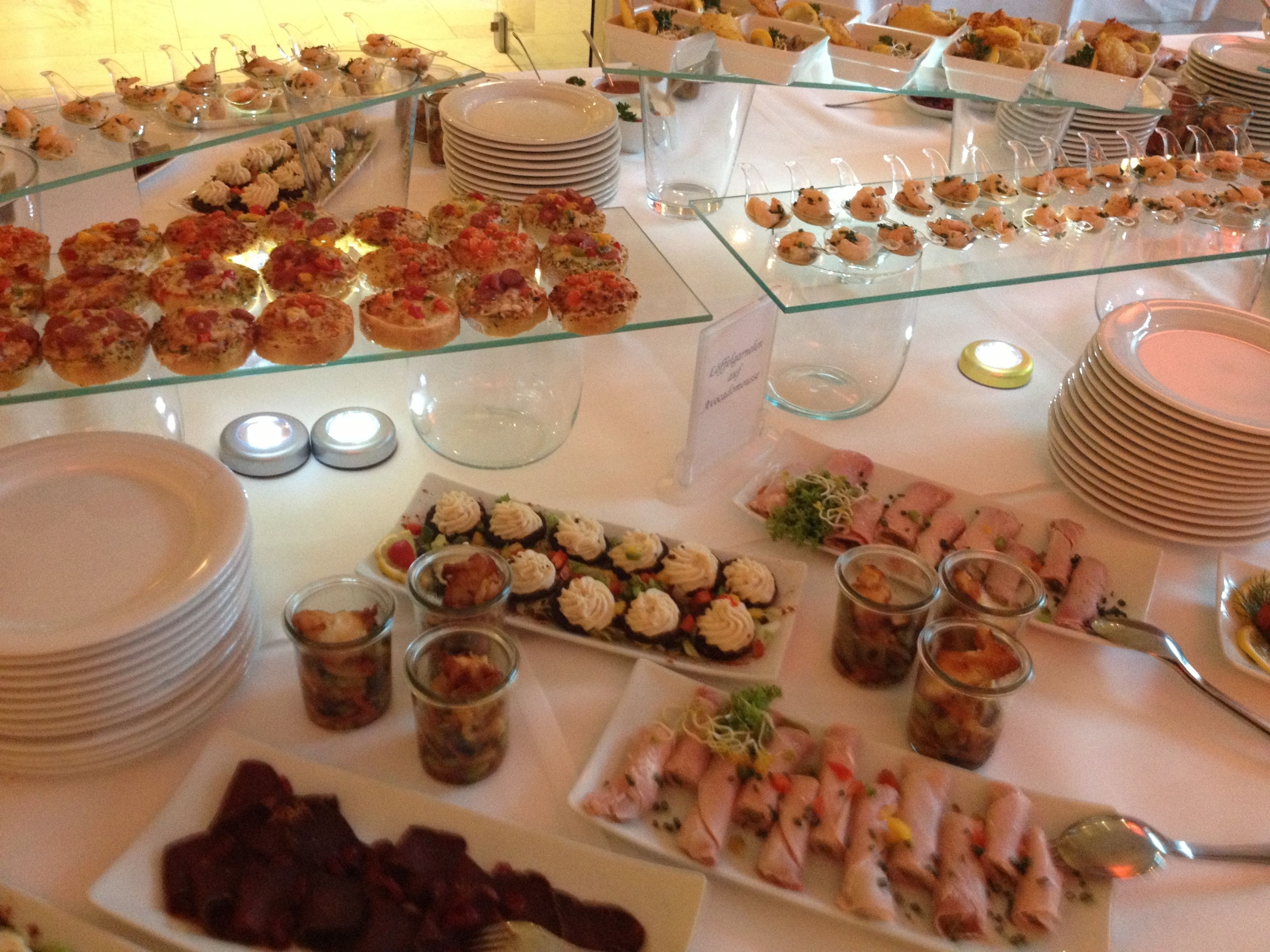 Un buffet con diversi cibi e piatti disposti su tavoli.