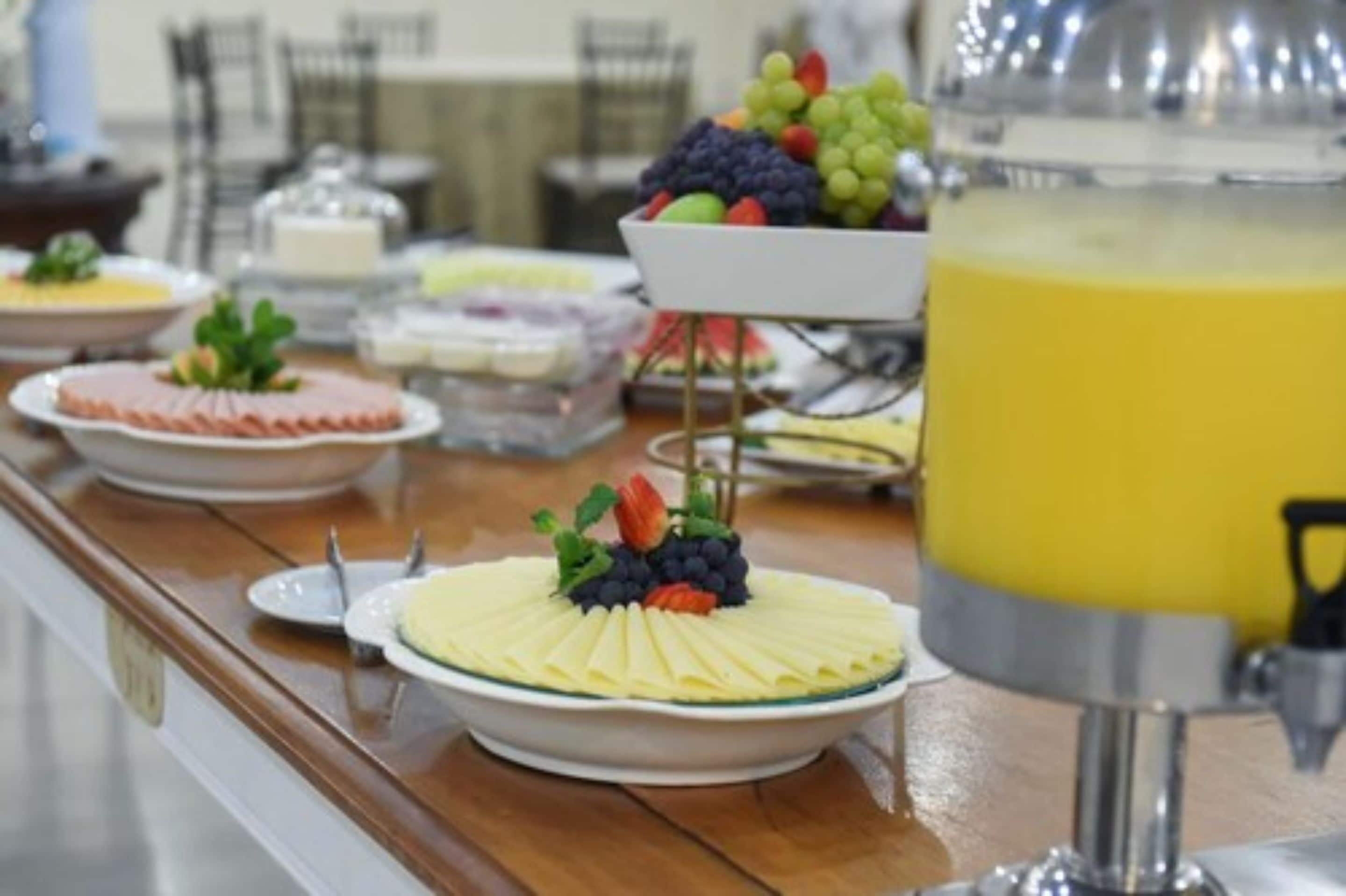 Un buffet proposant une variété de plats et une assiette de fruits.