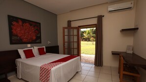 A bedroom with a bed, a desk, and a view of the outdoors. - Ipê Park Hotel (São José do Rio Preto)