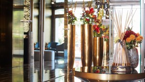 A lobby with a glass partition, a reception desk, and a seating area with chairs.