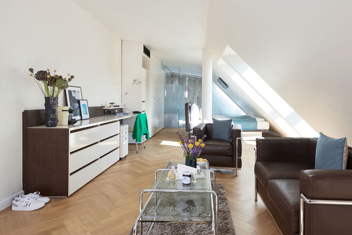A modern loft apartment with a kitchen, dining area, and living space.
