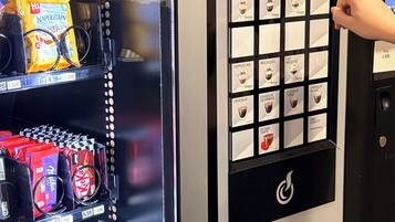 A self-service beverage vending machine with a selection of drinks and snacks.