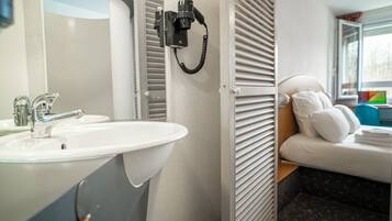 Un baño con lavamanos, espejo y teléfono.