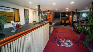 Et hotelværelse med reception, trappe og et venteområde med rød løber.