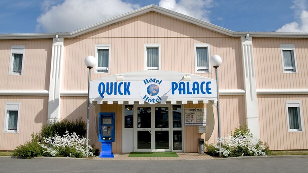 A hotel named 'Quick Palace Hotel' with a sign above the entrance, a blue information kiosk, and white-framed windows. - Quick Palace Vannes (Vannes)