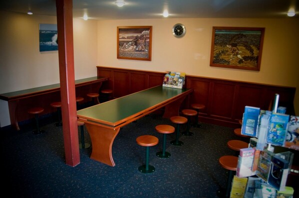 A bar area with a long counter, stools, and wall art.