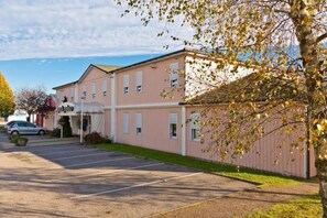 A pink building with a parking lot in front.