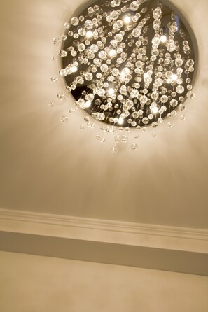 A ceiling with a circular chandelier featuring numerous clear crystal elements. - Suites Roma Tiburtina (Rome)