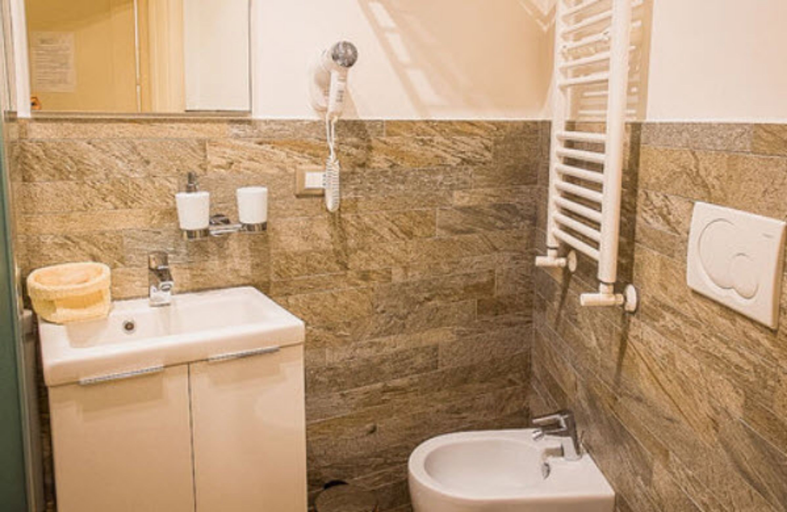 A bathroom with a sink, toilet, and towel rack.