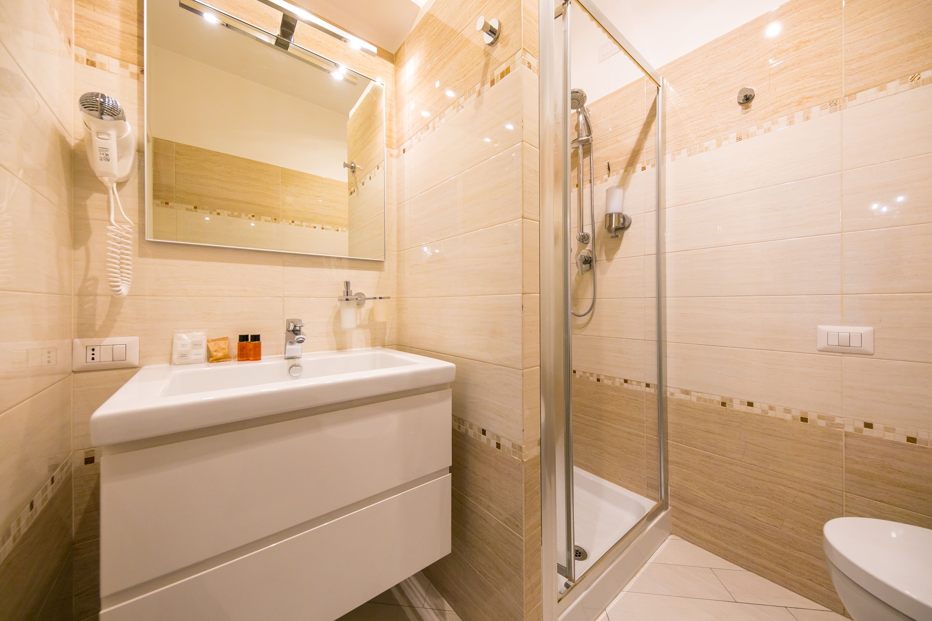 A modern bathroom with a sink, mirror, and shower.