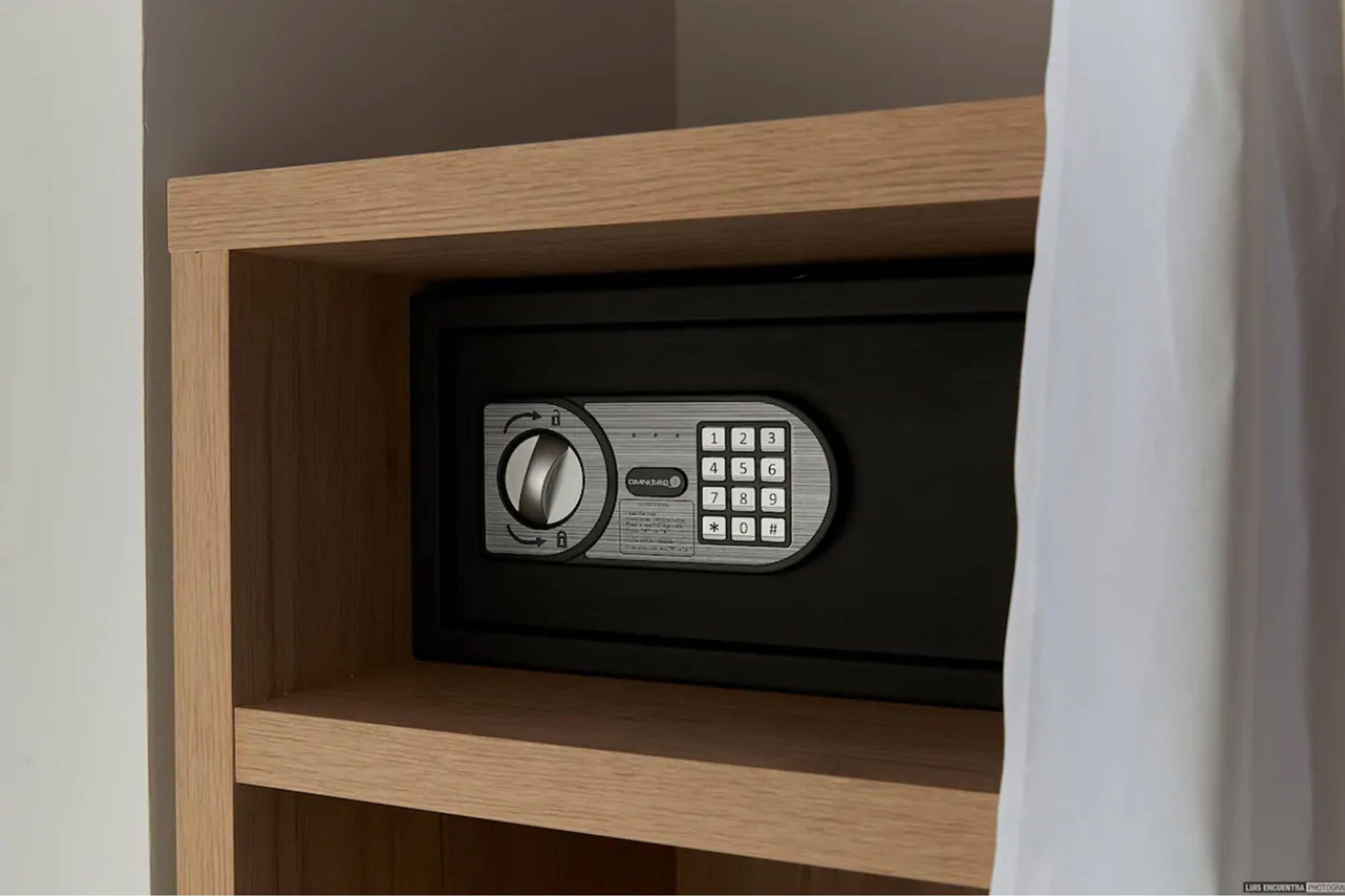 A secure storage unit with a combination lock and keypad, housed in a wooden cabinet.