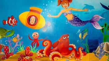 Un murale raffigura una sirena, un polpo e diverse creature marine.