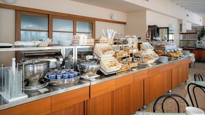 A buffet setup with various food items and serving utensils. - Hotel Villa Elena (Tortoreto)