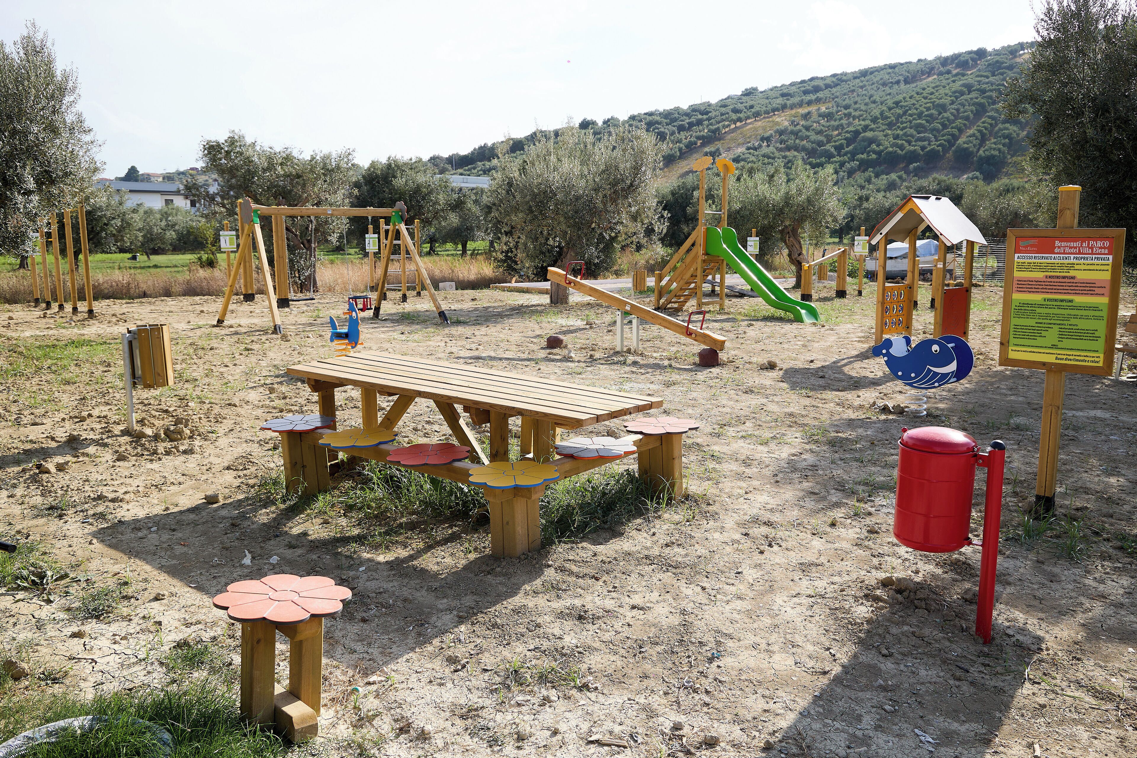 A playground with swings, slides, and a picnic table.
