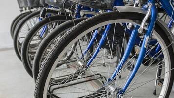 Varias bicicletas estacionadas en un garaje con un paredón amarillo y blanco al fondo.