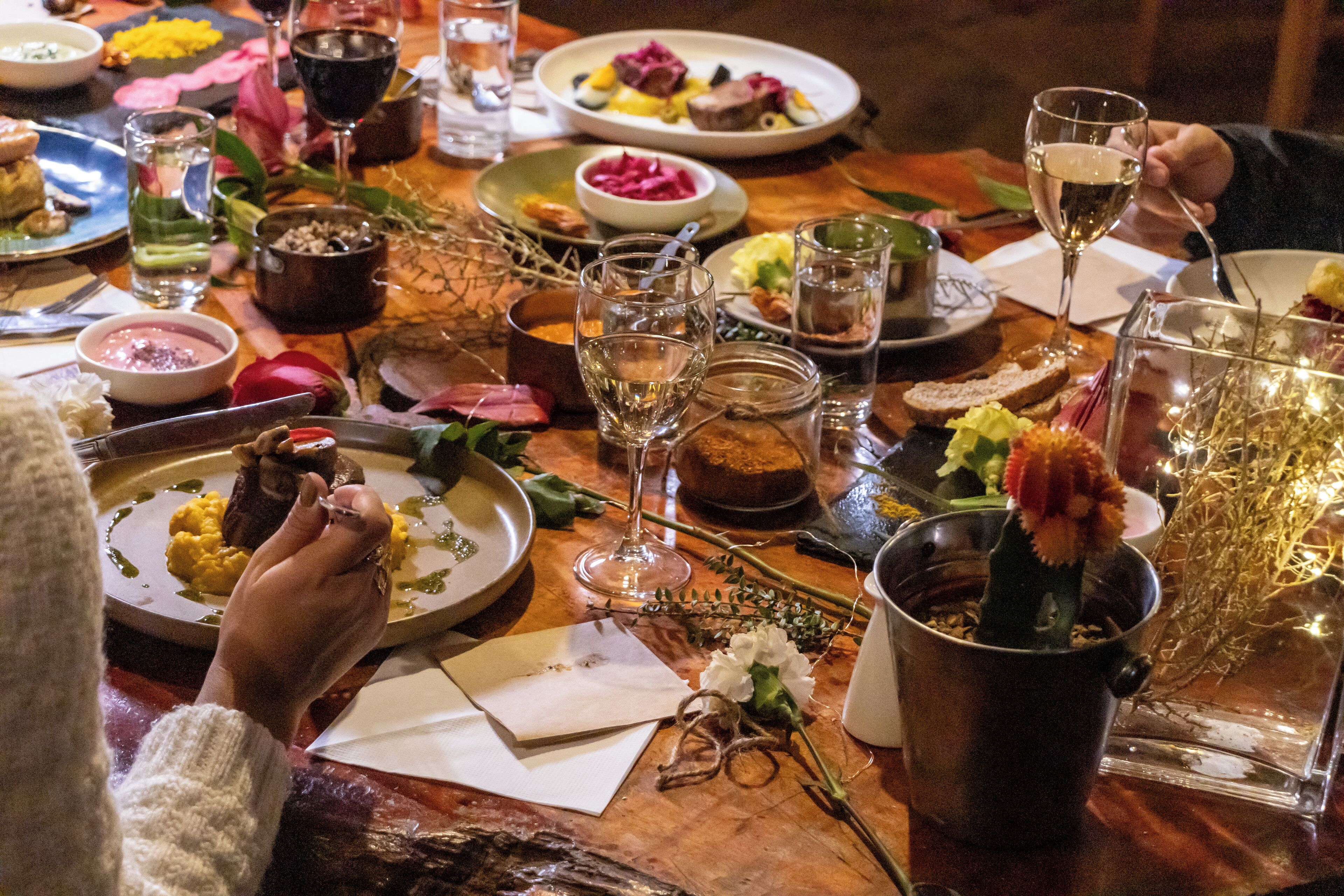A dining table with various dishes, glasses, and a potted plant.