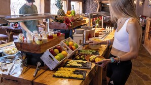 A buffet setup with various fruits, bowls, and utensils. - Don Raúl (San Pedro de Atacama)