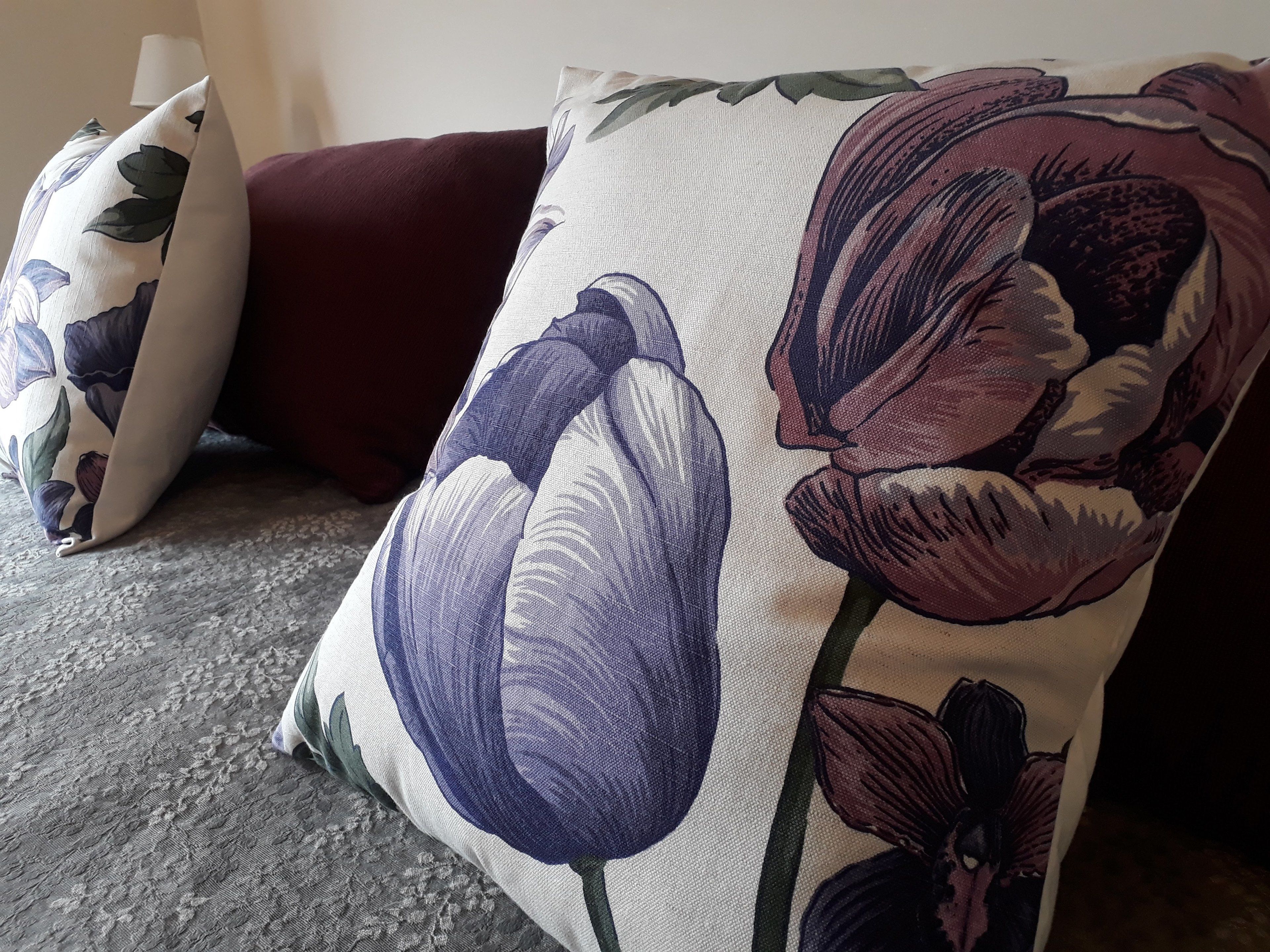 Un sofá con un cojín floral y una almohada a juego.