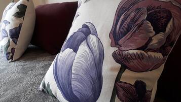 Un divano con un cuscino e un cuscino coordinato, entrambi decorati con motivi floreali.