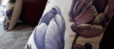Un sofá con un cojín floral y una almohada a juego.