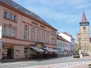 A historic building labeled "HOTEL PARIZ" with a clock tower in the background. - Hotel Paríz (Jicin)